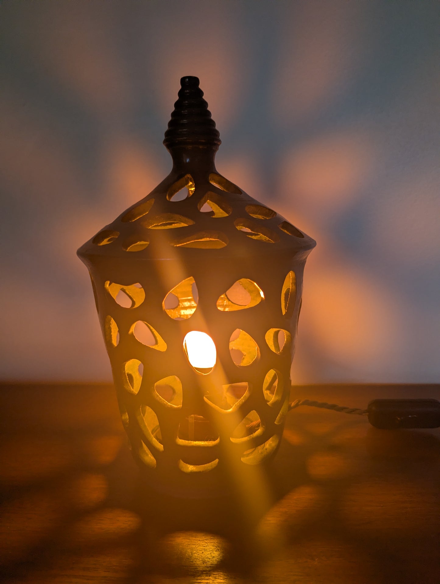 A ceramic mid twentieth century pottery table lamp on a wooden table top
