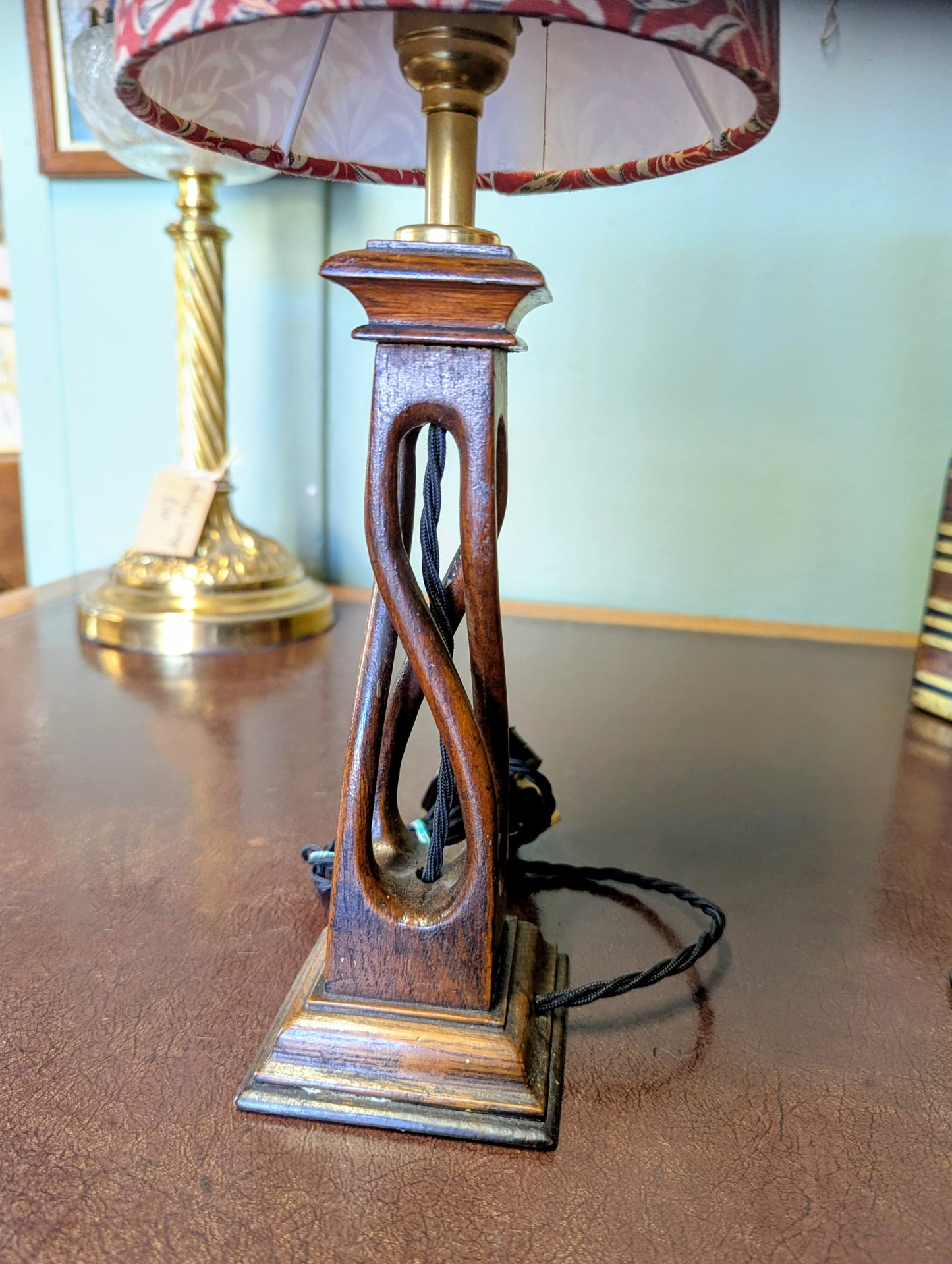 Wooden arts & crafts movement table lamp with decorative base on a wooden surface