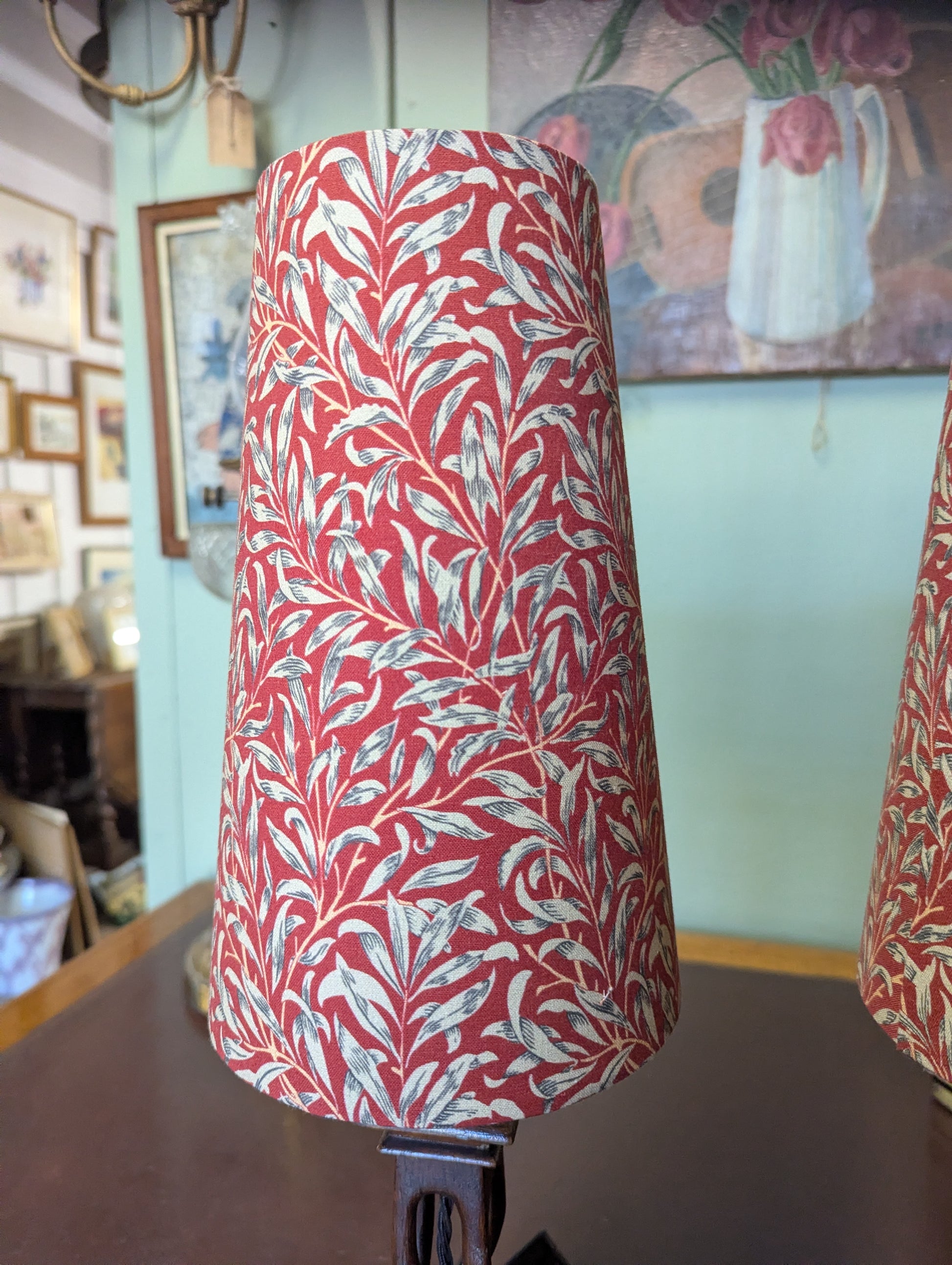 Red and white patterned lampshade on a wooden stand with a blurred indoor background