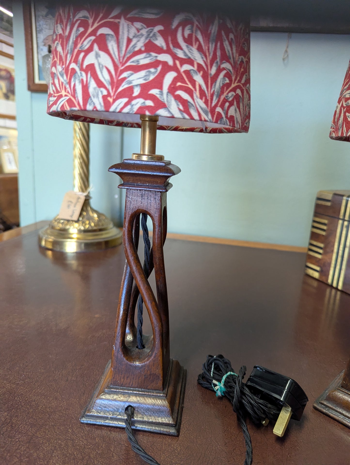Wooden lamp with a red and white patterned shade on a wooden surface.